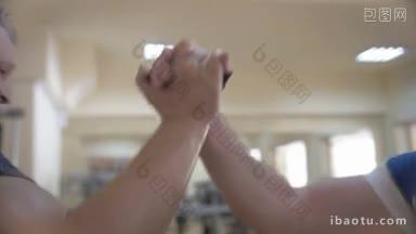 慢动作特写镜头，两个强壮的男人在健身房训练后坚定地握手，团队合作和<strong>友谊</strong>